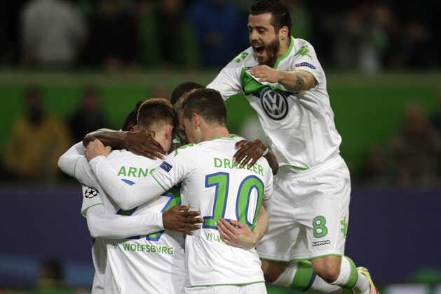 Wolfsburg's Maximilian Arnold, left, is congratulated by teammates after scoring their second goal during the Champions League first leg quarterfinal soccer match between VfL Wolfsburg and Real Madrid in Wolfsburg, Germany, Wednesday, April 6, 2016. (AP Photo/Michael Sohn)