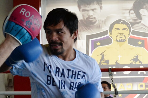 To go with Philippines-vote-religion-Box-PHI-Pacquiao,FOCUS by Karl Malakunas
This photo taken on February 15, 2016 shows Philippine boxing legend Manny Pacquiao sparring with his coach Freddie Roach as part of his training at a gym in General Santos City in the southern Philipppine island of Mindanao. Manny Pacquiao still trains with the joy that has been a trademark of his spectacular boxing career, but outside of the ring he speaks in ominous, Biblical tones about his political crusade against wickedness. Pacquiao, already a congressman, is running for a Senate seat in May elections -- with an eye on an eventual presidential run -- and his star power in a nation famed for its celebrity-obsessed politics is likely to see him win. AFP PHOTO / TED ALJIBE / AFP / TED ALJIBE        (Photo credit should read TED ALJIBE/AFP/Getty Images)