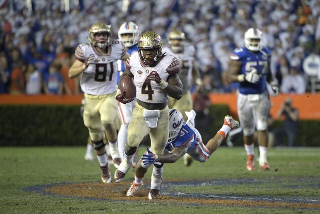 Florida State running back Dalvin Cook (4) rushes for yardage past Florida defensive back Jalen Tabor (31) during the second half of an NCAA college football game in Gainesville, Fla., Saturday, Nov. 28, 2015. Florida State won 27-2. (AP Photo/Phelan M. Ebenhack)