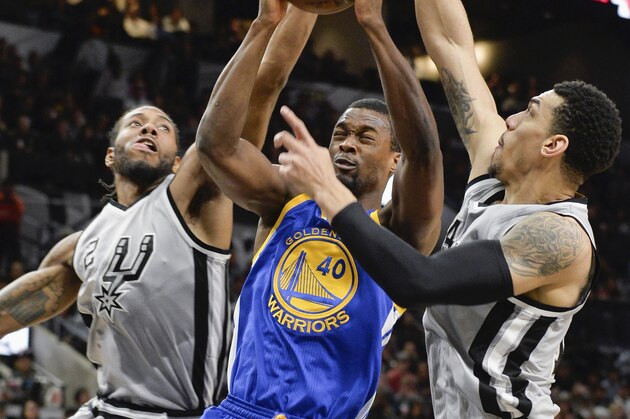 Golden State Warriors forward Harrison Barnes (40) attempts to shoot between San Antonio Spurs' Kawhi Leonard (2), and Danny Green during the first half of an NBA basketball game, Saturday, March 19, 2016, in San Antonio. (AP Photo/Darren Abate)
