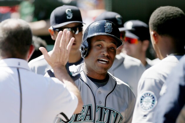 Seattle Mariners' Robinson Cano is congratulated by teammates after hitting a solo home run during the first inning of a baseball game against the Texas Rangers, Monday, April 4, 2016, in Arlington, Texas. (AP Photo/Brandon Wade)