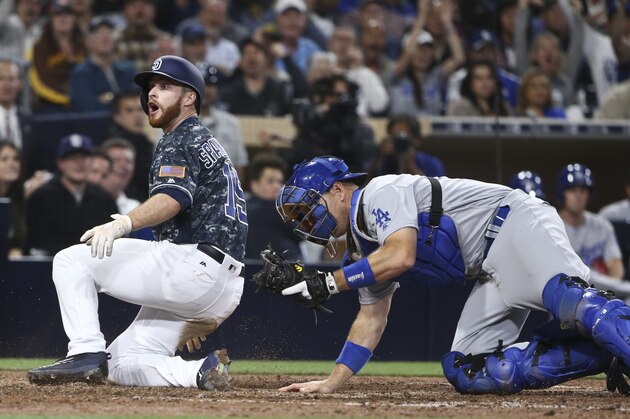 San Diego Padres' Cory Spangenberg reacts to the umpire's out call as Los Angeles Dodgers catcher A.J. Ellis holds the ball during the sixth inning of a baseball game Wednesday, April 6, 2016, in San Diego. (AP Photo/Lenny Ignelzi)