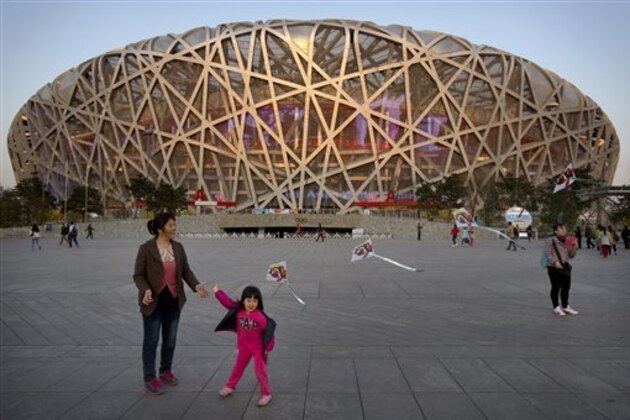 FILE - In this March 28, 2015 file photo, of a girl as she flies a kite on Olympic Green near Beijing National Stadium, also known as the Birds Nest.  The IAAF said Tuesday Aug. 11, 2015 that 28 athletes tested positive after their doping samples from the 2005 and 2007 world championships were reanalyzed. Track and field's governing body did not name any of the athletes, who produced 32 positive findings in tests from the 2005 championships in Helsinki and 2007 meeting in Osaka. The next athletics world championships will begin in Beijing on Aug. 22 . (AP Photo/Mark Schiefelbein, File)