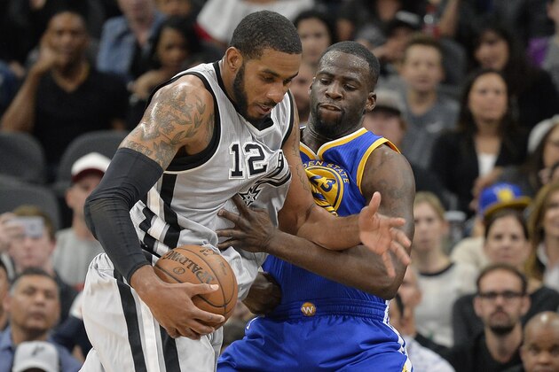 San Antonio Spurs forward LaMarcus Aldridge (12) tangles with Golden State Warriors forward Draymond Green during the first half of an NBA basketball game, Saturday, March 19, 2016, in San Antonio. San Antonio won 87-79. (AP Photo/Darren Abate)