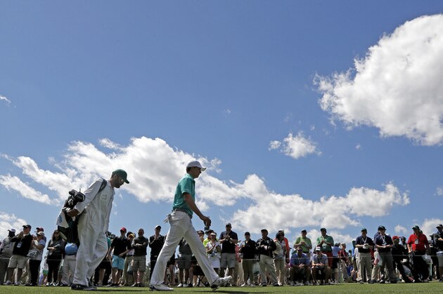 Jordan Spieth and his caddie Michael Greller walk down the 18th fairway during the first round of the Masters golf tournament Thursday, April 7, 2016, in Augusta, Ga. (AP Photo/Charlie Riedel)