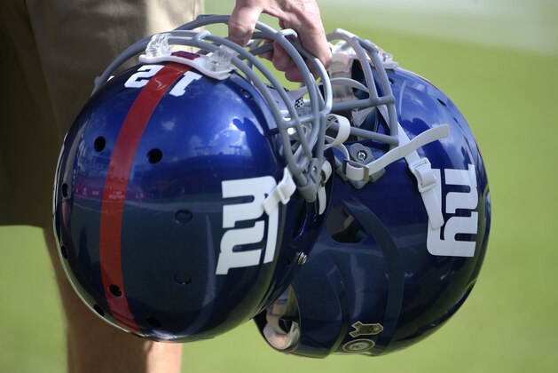 New York Giants trainers carry helmets on the field during warmups before an NFL football game against the Tampa Bay Buccaneers in Tampa, Fla., Sunday, Nov. 8, 2015. The Giants won 32-18. (AP Photo/Phelan M. Ebenhack)