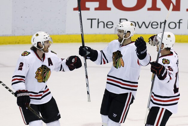 Chicago Blackhawks' Andrew Ladd, center, celebrates his third-period goal with Duncan Keith (2) and Jonathan Toews, right, during an NHL hockey game against the Detroit Red Wings on Wednesday, March 2, 2016, in Detroit. The Blackhawks won, 5-2. (AP Photo/Duane Burleson)
