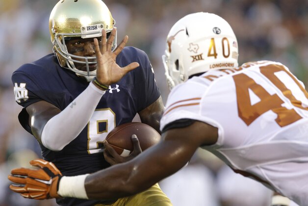 Notre Dame quarterback Malik Zaire, left, runs with the ball against Texas defensive end Naashon Hughes during the first half of an NCAA college football game Saturday, Sept. 5, 2015, in South Bend, Ind. (AP Photo/Nam Y. Huh)