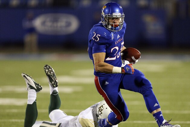 Kansas Jayhawks running back Brandon Bourbon (25) slips past Baylor Bears cornerback Ryan Reid for a touchdown in the third quarter of an NCAA college football game Saturday, Oct. 26, 2013, in Lawrence, Kan. Baylor won 59-14. (AP Photo/Ed Zurga)