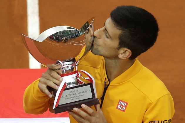 Novak Djokovic of Serbia kisses his trophy after defeating Thomas Berdych of Czech republic in their final match of the Monte Carlo Tennis Masters tournament in Monaco, Sunday, April 19, 2015. (AP Photo/Lionel Cironneau)