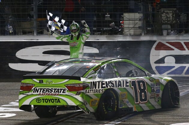 Kyle Busch celebrates after winning the NASCAR Sprint Cup Series auto race at Texas Motor Speedway in Fort Worth, Texas, early Sunday, April 10, 2016. (AP Photo/Ralph Lauer)