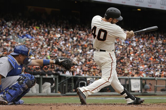 San Francisco Giants' Madison Bumgarner (40) hits a solo home run in front of Los Angeles Dodgers catcher A.J. Ellis during the second inning of a baseball game in San Francisco, Saturday, April 9, 2016. (AP Photo/Jeff Chiu)