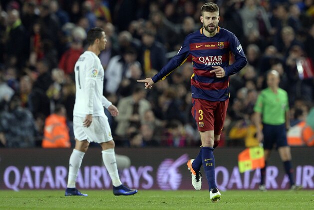 Barcelona's defender Gerard Pique (R) celebrates a goal as he runs past Real Madrid's Portuguese forward Cristiano Ronaldo during the Spanish league 'Clasico' football match FC Barcelona vs Real Madrid CF at the Camp Nou stadium in Barcelona on April 2, 2016. / AFP / JOSEP LAGO        (Photo credit should read JOSEP LAGO/AFP/Getty Images)