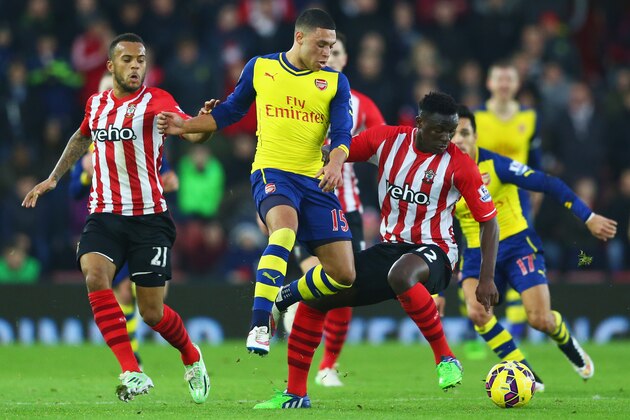 SOUTHAMPTON, ENGLAND - JANUARY 01:  Alex Oxlade-Chamberlain of Arsenal takes on Victor Wanyama (R) and Ryan Bertrand of Southampton (L) during the Barclays Premier League match between Southampton and Arsenal at St Mary's Stadium on January 1, 2015 in Southampton, England.  (Photo by Michael Steele/Getty Images)