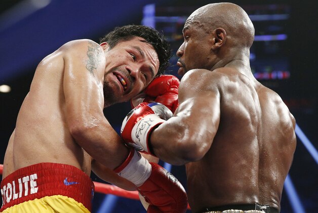 FILE - This May 2, 2015 file photo shows Manny Pacquiao, from the Philippines, left, trades punches with Floyd Mayweather Jr., during their welterweight title fight in Las Vegas. Boxing fans across the country or at least their lawyers are calling the hyped-up fight between Pacquiao and Mayweather a fraud. Some 31 class action lawsuits had been filed through Friday alleging primarily the same thing: that Pacquiao's pre-existing shoulder injury should have been disclosed to fans ahead of time.  (AP Photo/John Locher, File)