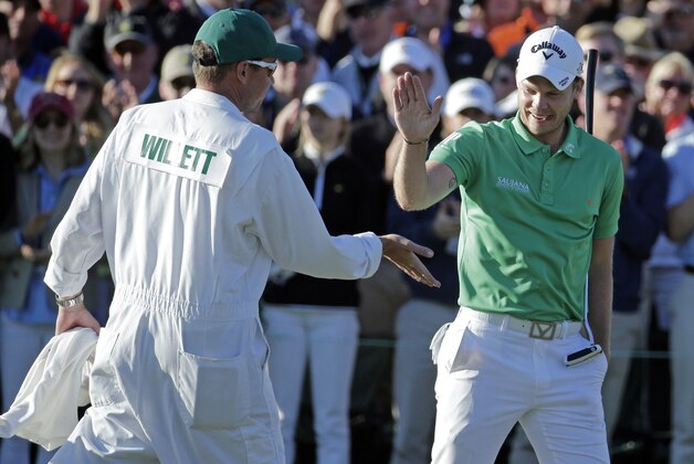 Danny Willett, of England, is congratulated by his caddie Jonathan Smart on the 18th hole after his final round of the Masters golf tournament Sunday, April 10, 2016, in Augusta, Ga. (AP Photo/Charlie Riedel)