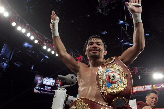 TOPSHOT - Manny Pacquiao gestures to fans celebrating after defeating Timothy Bradley Jr. in a 12 round unanimous decision at the MGM Grand Arena on April 9, 2016 in Las Vegas, Nevada. 
Pacquio captured the WBO International Welterweight Title. / AFP / John GURZINSKI        (Photo credit should read JOHN GURZINSKI/AFP/Getty Images)