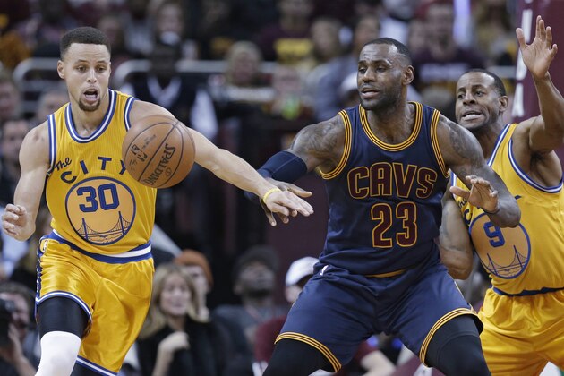 Golden State Warriors’ Stephen Curry (30) knocks the ball loose from Cleveland Cavaliers' LeBron James (23) in the first half of an NBA basketball game, Monday, Jan. 18, 2016, in Cleveland. Andre Iguodala (9) is at right. (AP Photo/Tony Dejak)