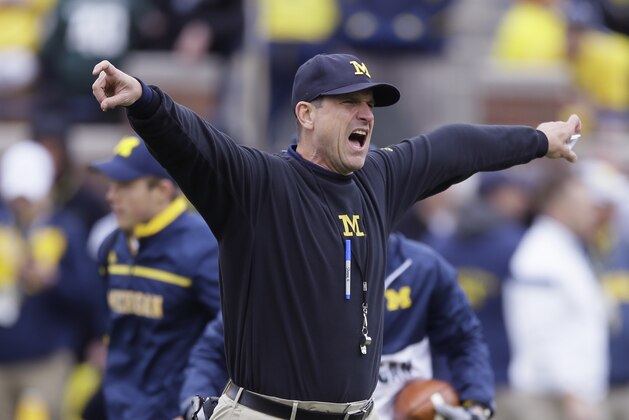 Michigan head coach Jim Harbaugh instructs during pre-game of an NCAA college football game against Michigan State, Saturday, Oct. 17, 2015, in Ann Arbor, Mich. (AP Photo/Carlos Osorio)