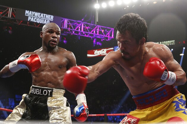 Floyd Mayweather Jr. exchange punches with Manny Pacquiao during their welterweight unification championship bout, May 2, 2015 at MGM Grand Garden Arena in Las Vegas, Nevada.  Mayweather defeated Pacquiao by unanimous decision.  AFP PHOTO / JOHN GURZINKSI        (Photo credit should read JOHN GURZINSKI/AFP/Getty Images)