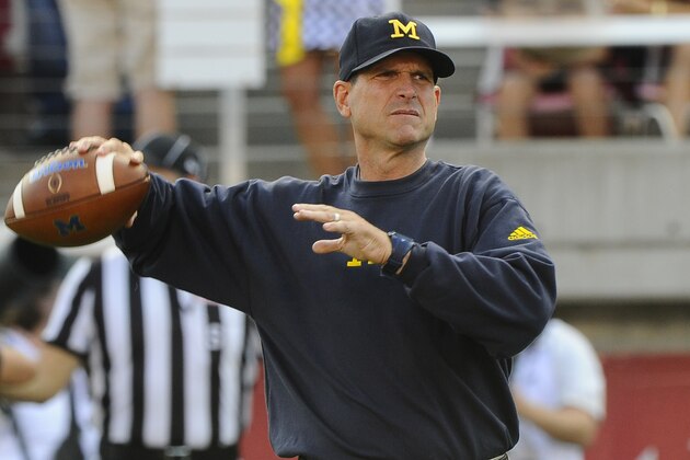 SALT LAKE CITY, UT - SEPTEMBER 3: Head coach Jim Harbaugh of the Michigan Wolverines warms up his quarterbacks before their game against the Utah Utes at  Rice-Eccles Stadium on September 3, 2015 in Salt Lake City, Utah. (Photo by Gene Sweeney Jr/Getty Images)