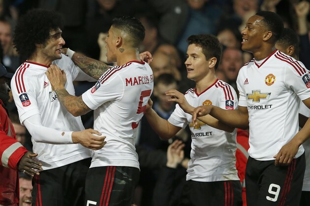 United’s Marouane Fellaini, left, celebrates with teammates after scoring during the English FA Cup quarterfinal replay soccer match between West Ham and Manchester United at Boleyn Ground stadium in London, Wednesday, April 13, 2016.(AP Photo/Alastair Grant)