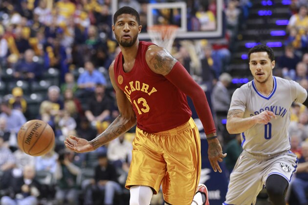 Paul George, alero de los Pacers de Indiana, envía un pase junto a Shane Larkin, de los Nets de Brooklyn, en el encuentro disputado el domingo 10 de abril de 2016 (AP Foto/R Brent Smith)