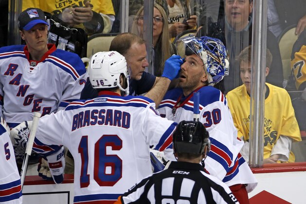 New York Rangers goalie Henrik Lundqvist (30) is tended to by a trainer after getting a stick in the face during the first period of a first-round NHL playoff hockey game in Pittsburgh, Wednesday, April 13, 2016.  Lundqvist remained in the game. (AP Photo/Gene J. Puskar)