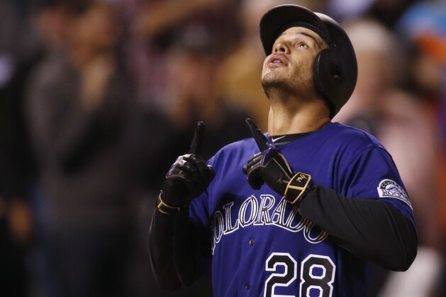 Colorado Rockies' Nolan Arenado gestures as he crosses home plate after hitting a three-run home run off San Francisco Giants relief pitcher Josh Osich in the eighth inning of a baseball game Wednesday, April 13, 2016, in Denver. Colorado won 10-6. (AP Photo/David Zalubowski)