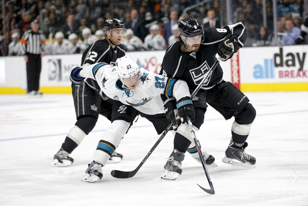 San Jose Sharks' Joonas Donskoi, left, of Finland, and Los Angeles Kings' Drew Doughty fight for the puck during the third period of an NHL hockey game, Tuesday, Dec. 22, 2015, in Los Angeles. The Sharks won 5-3. (AP Photo/Jae C. Hong)