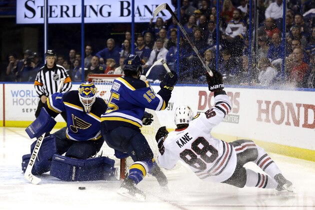 Chicago Blackhawks' Patrick Kane, right, falls after being tripped up on his way to the net by St. Louis Blues' Robby Fabbri, center, as Blues goalie Brian Elliott, left, watches during the third period in Game 1 of an NHL hockey first-round Stanley Cup playoff series Wednesday, April 13, 2016, in St. Louis. (AP Photo/Jeff Roberson)