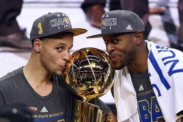 CLEVELAND, OH - JUNE 16:  Stephen Curry #30 and Andre Iguodala #9 of the Golden State Warriors celebrate with the Larry O'Brien NBA Championship Trophy after defeating the Cleveland Cavaliers in Game Six of the 2015 NBA Finals at Quicken Loans Arena on June 16, 2015 in Cleveland, Ohio. NOTE TO USER: User expressly acknowledges and agrees that, by downloading and or using this photograph, user is consenting to the terms and conditions of Getty Images License Agreement.  (Photo by Jason Miller/Getty Images)