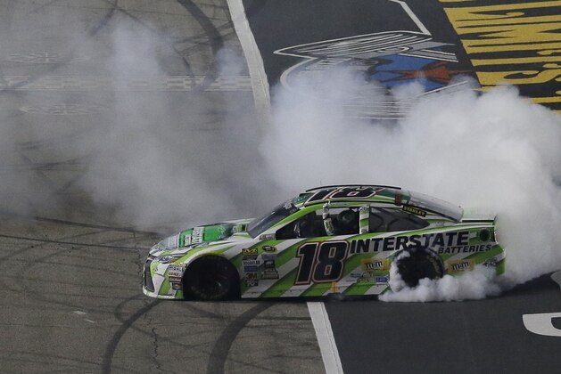 Kyle Busch (18) burns his tires after winning the NASCAR Sprint Cup Series auto race at Texas Motor Speedway in Fort Worth, Texas, Sunday, April 10, 2016.  (AP Photo/Tim Sharp)