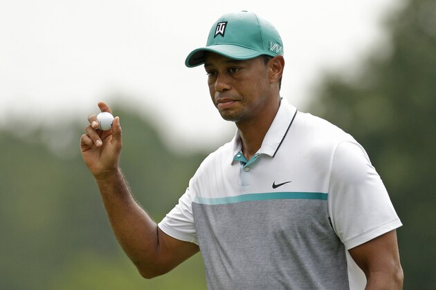 Tiger Woods acknowledges the crowd after finishing his round on the ninth hole during the first round of the Wyndham Championship golf tournament in Greensboro, N.C., Thursday, Aug. 20, 2015. (AP Photo/Chuck Burton)