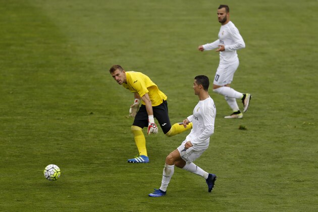 Real Madrid's Cristiano Ronaldo, front, scores past Getafe's goalkeeper Vicente Guaita during a Spanish La Liga soccer match between Real Madrid and Getafe at the Alfonso Perez stadium in Getafe, near Madrid, Saturday, April 16, 2016. Ronaldo scored once in Real Madrid's 5-1 victory. (AP Photo/Francisco Seco)