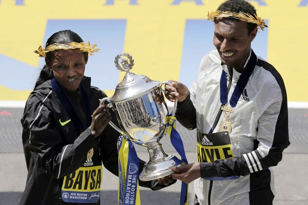 Atsede Baysa, left, and Lemi Berhanu Hayle, both of Ethiopia, hold a trophy after they won the women's and men's divisions of the 120th Boston Marathon on Monday, April 18, 2016, in Boston. (AP Photo/Charles Krupa)