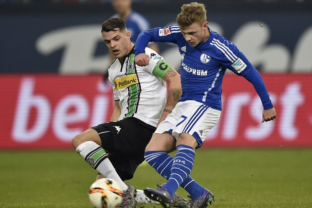 Moenchengladbach's Granit Xhaka, left, is challenged by Schalke's Max Meyer during the German Bundesliga soccer match between FC Schalke 04 and Borussia Moenchengladbach in Gelsenkirchen, Germany, Friday, March 18, 2016. (AP Photo/Martin Meissner)