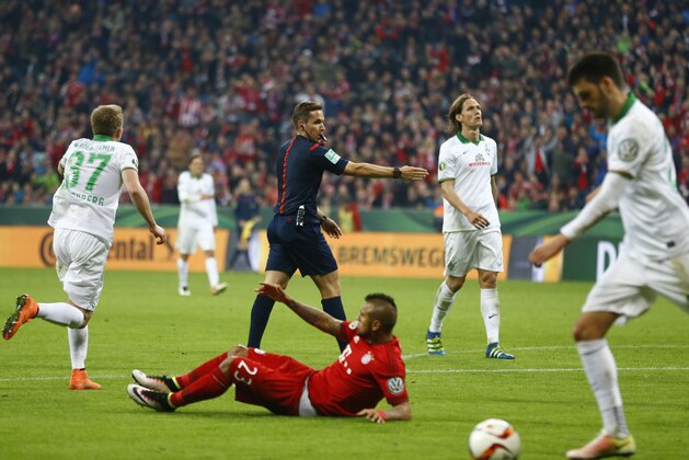 Referee Tobias Stieler, center, gestures to the penalty spot after Bayern's Arturo Vidal, center bottom, was fouled by Bremen's Janek Sternberg, left, during the German soccer cup (DFB Pokal) semi final match between FC Bayern Munich and SV Werder Bremen at the Allianz Arena stadium in Munich, Germany, Tuesday, April 19, 2016. (AP Photo/Matthias Schrader)