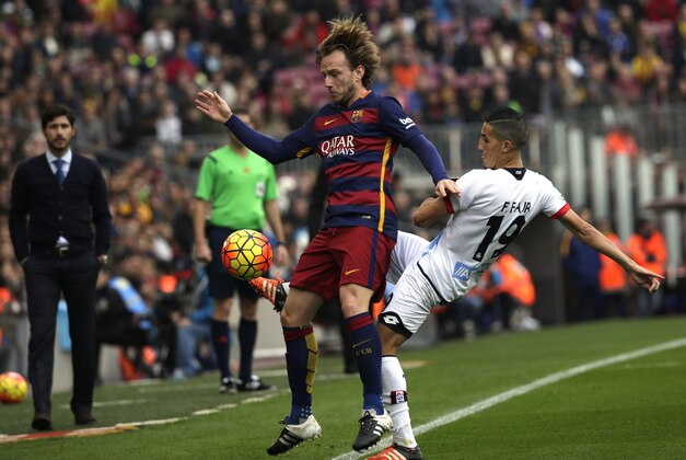 Barcelona's Ivan Rakitic, front, fights for the ball against Deportivo's Faycal Fajr during a Spanish La Liga soccer match between FC Barcelona and Deportivo Coruna at the Camp Nou stadium in Barcelona, Spain, Saturday, Dec. 12, 2015. (AP Photo/ Emilio Morenatti)