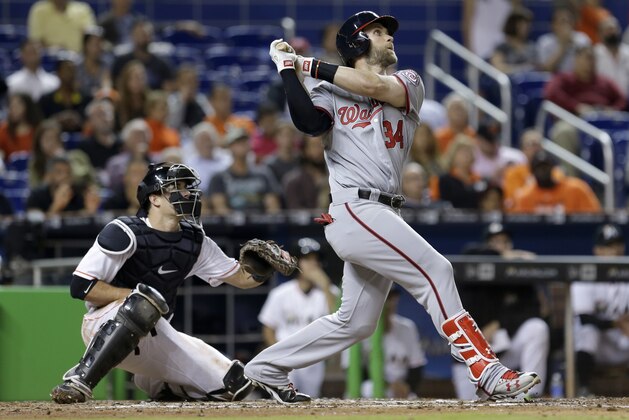 Washington Nationals' Bryce Harper (34) follows through on a sacrifice fly against the Miami Marlins during the fifth inning of a baseball game, Monday, April 18, 2016, in Miami. Washington Nationals center fielder Michael Taylor (3) scored on the sacrifice fly. (AP Photo/Alan Diaz)