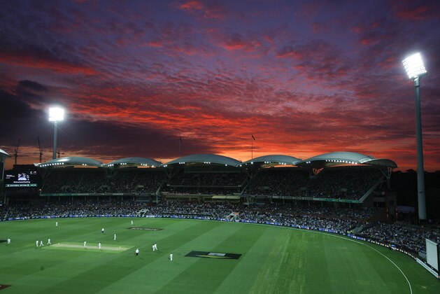 Lights illuminate the Adelaide Oval as the sun sets during the first night session of the cricket test between Australia and New Zealand in Adelaide, Friday, Nov. 27, 2015. This match is the sport's first ever day-night test and the use of the “experimental” pink leather ball replacing the standard-issue red for the first time in a format that dates back to the 1870s. (AP Photo/Rick Rycroft)