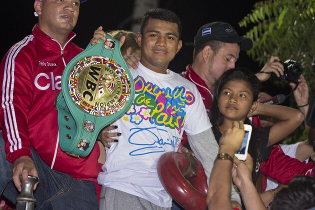Nicaragua's three time boxing world champion Roman Gonzalez, holds the WBC title belt as he rides on top of a fire truck into Managua in a victory celebration, after his arrival at a international airport in Managua, Nicaragua, Monday, Oct. 19, 2015. Gonzalez defeated Brian Viloria in the eighth round of an WBC flyweight title bout at the Madison Square Garden in New York on Saturday. (AP Photo/Esteban Felix)