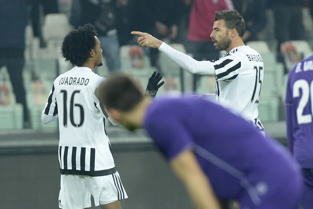 Juventus' Juan Cuadrado, left, celebrates with is teammates Andrea Barzagli after scoring during a Serie A soccer match between Juventus and Fiorentina  at the Juventus stadium, in Turin, Italy, Sunday, Dec. 13, 2015. (AP Photo/ Massimo Pinca)