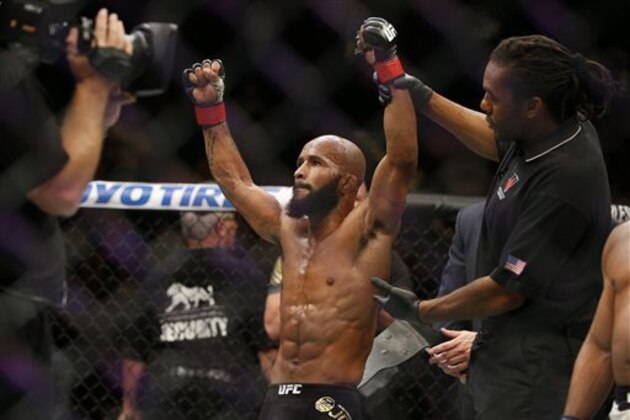 CORRECTS NAME TO DEMETRIOUS FROM DEMETRIUS - Demetrious Johnson celebrates after defeating John Dodson during their flyweight title mixed martial arts bout at UFC 191, Saturday, Sept. 5, 2015, in Las Vegas. (AP Photo/John Locher)