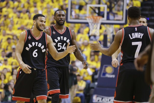 Toronto Raptors guard Kyle Lowry (7) greets guard Cory Joseph (6) and forward Patrick Patterson (54) as they come off the court for a timeout during the first half of Game 3 of an NBA first-round playoff basketball series against the Indiana Pacers in Indianapolis, Thursday, April 21, 2016. (AP Photo/Michael Conroy)