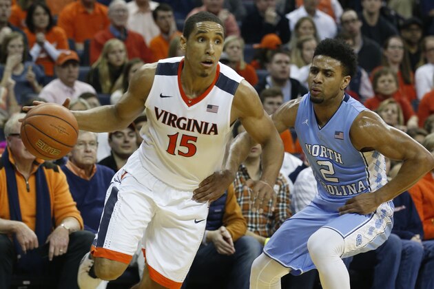 In this photo taken, Saturday Feb. 27, 2016, Virginia guard Malcolm Brogdon (15) drives to the basket past North Carolina guard Joel Berry II (2) during the second half of an NCAA college basketball game in Charlottesville, Va. Brogdon has been at the heart of winning games, leading Virginia in scoring for three consecutive years. (AP Photo/Steve Helber)