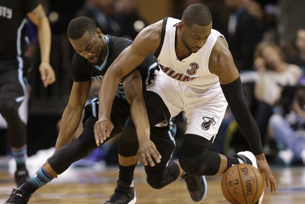 Charlotte Hornets' Kemba Walker, left, knocks the ball from Miami Heat's Dwyane Wade, right, during the second half in Game 3 of an NBA basketball playoffs first-round series in Charlotte, N.C., Saturday, April 23, 2016. The Hornets won 96-80. (AP Photo/Chuck Burton)