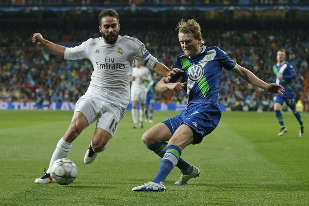 Real Madrid's Dani Carvajal, left, and Wolfsburg's Andre Schuerrle, right, vie for the ball during the Champions League 2nd leg quarterfinal soccer match between Real Madrid and VfL Wolfsburg at the Santiago Bernabeu stadium in Madrid, Spain, Tuesday April 12, 2016. (AP Photo/Paul White)