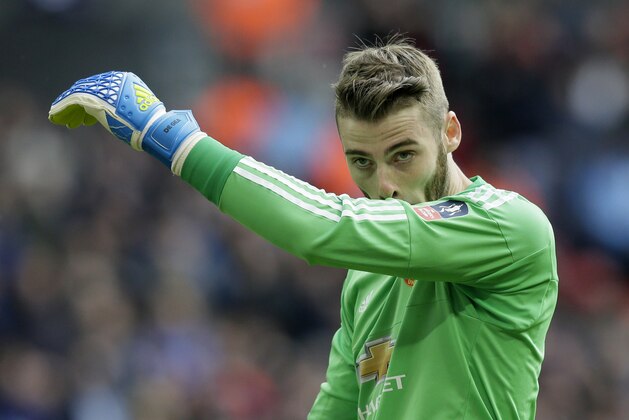 Manchester United's goalkeeper David de Gea wipes his face on this sleeve after saving a penalty taken by Everton’s Romelu Lukaku during the English FA Cup semifinal between Manchester United and Everton at Wembley stadium in London, Saturday, April 23,  2016. (AP Photo/Tim Ireland)