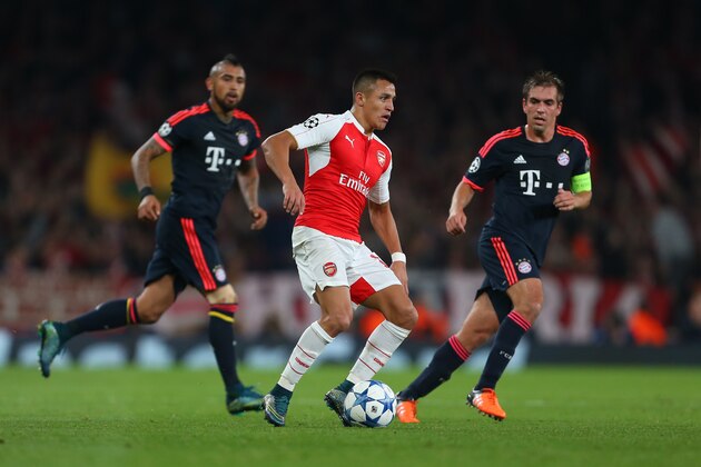 LONDON, ENGLAND - OCTOBER 20:  Alexis Sanchez of Arsenal gets past Arturo Vidal and Philipp Lahm of Bayern Munich during the UEFA Champions League match between Arsenal and Bayern Munich at the Emirates Stadium on October 20, 2015 in London, United Kingdom.  (Photo by Catherine Ivill - AMA/Getty Images)